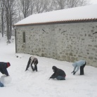 Skavti pri izdelovanju snežaka, v ozadju cerkev sv Lovrenca